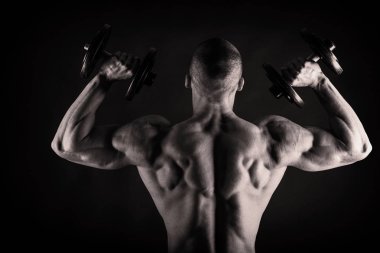 Bir adam siyah bir zemin üzerine muhteşem bir kas vücut ile