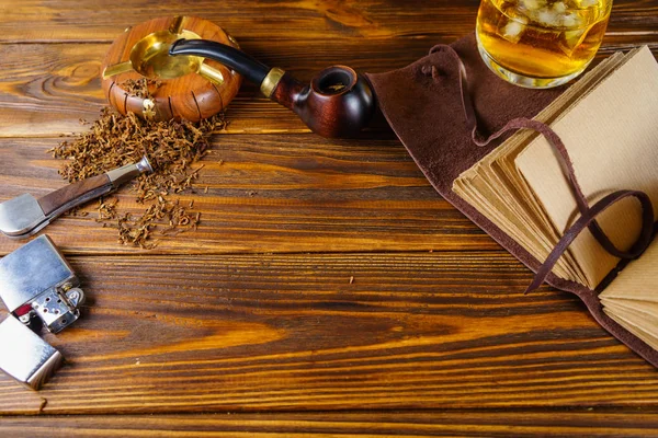 Background on the topic of men's rest. Pipe, whiskey and noteboo — Stock Photo, Image