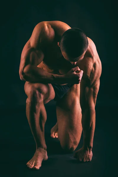 Muskularne męskie ciało na ciemnym tle. — Zdjęcie stockowe