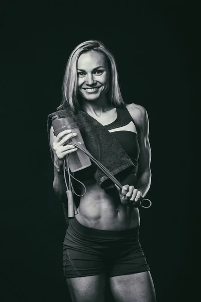 Figuur fitness meisje op een donkere achtergrond. — Stockfoto