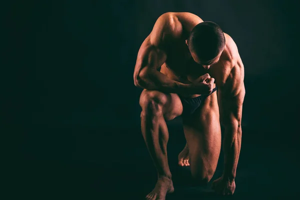 Corpo masculino muscular em um fundo escuro . — Fotografia de Stock