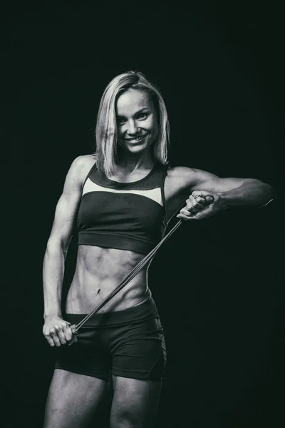 Figur fitness tjej på en mörk bakgrund. — Stockfoto