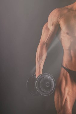 Bir adam siyah bir zemin üzerine muhteşem bir kas vücut ile