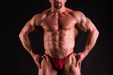 karanlık bir arka plan üzerinde poz vücut geliştirmeci.