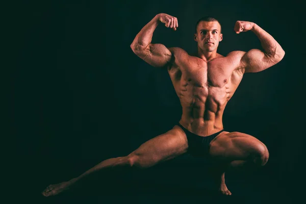 Muskularne męskie ciało na ciemnym tle. — Zdjęcie stockowe
