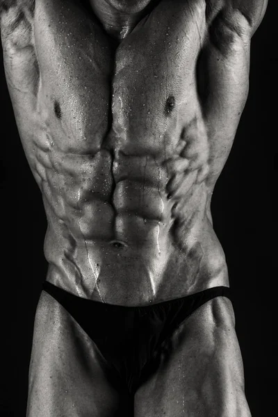 Bir adam siyah bir zemin üzerine muhteşem bir kas vücut ile — Stok fotoğraf