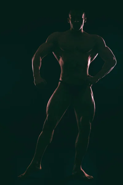 М'язисте чоловіче тіло на темному фоні . — стокове фото