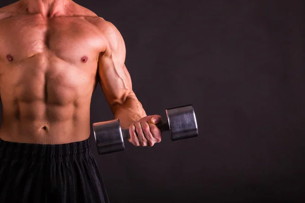 Potenza maschile fitness su uno sfondo scuro . — Foto Stock