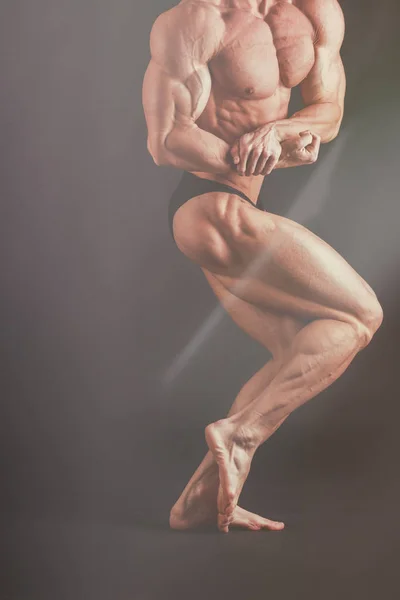 Ένας άνθρωπος με ένα πανέμορφο μυώδες σώμα σε μαύρο φόντο — Φωτογραφία Αρχείου