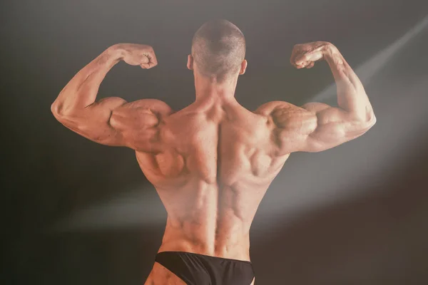 A man with a gorgeous muscular body on a black background — Stock Photo, Image