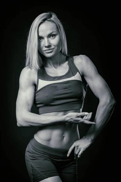 Hermosa figura deportiva sobre un fondo oscuro . — Foto de Stock