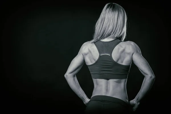 Hermosa figura deportiva sobre un fondo oscuro . — Foto de Stock