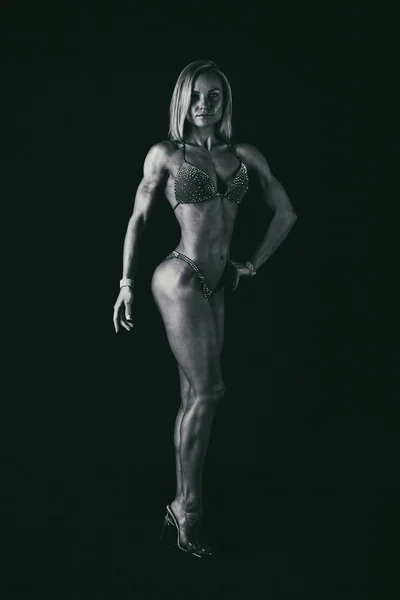 Atleta de fitness profesional sobre un fondo oscuro . — Foto de Stock