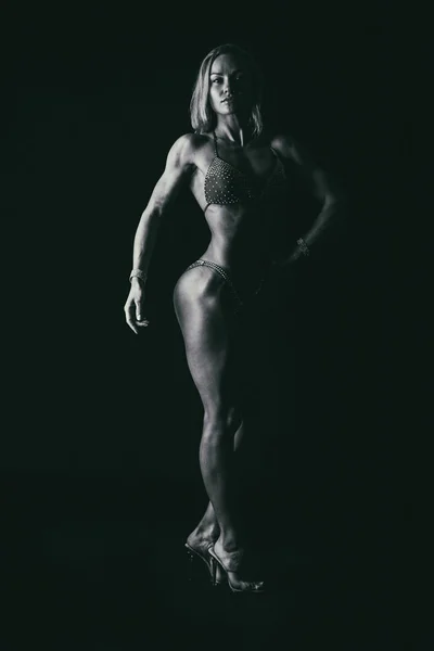 Atleta de fitness profesional sobre un fondo oscuro . — Foto de Stock