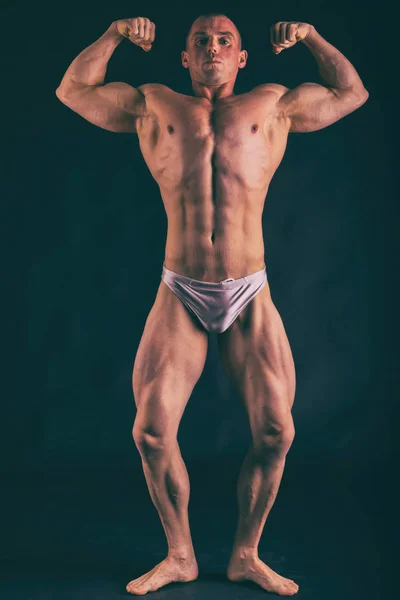 Bodybuilder posieren in verschiedenen Posen und demonstrieren ihre Muskeln — Stockfoto