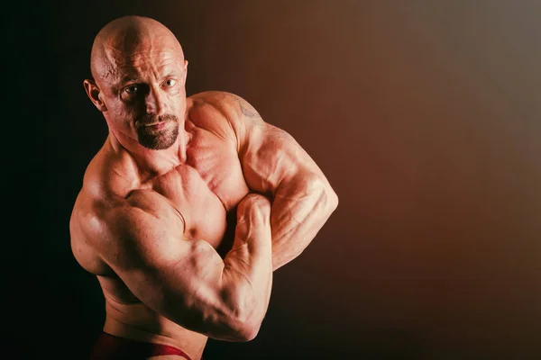 Bodybuilder auf schwarzem Hintergrund. — Stockfoto