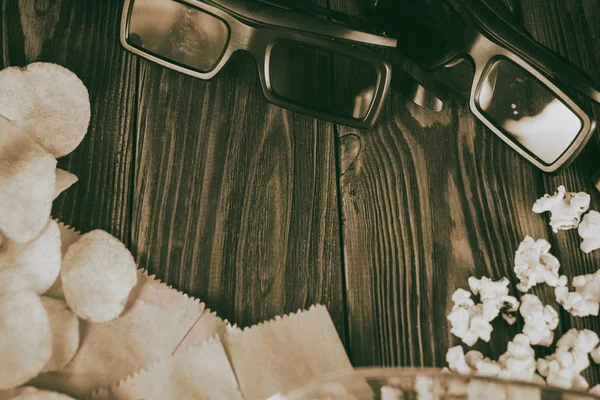 Pipocas soltas e óculos 3D em um fundo de madeira — Fotografia de Stock