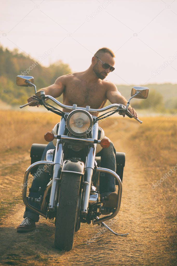 Macho on a motorcycle in a field
