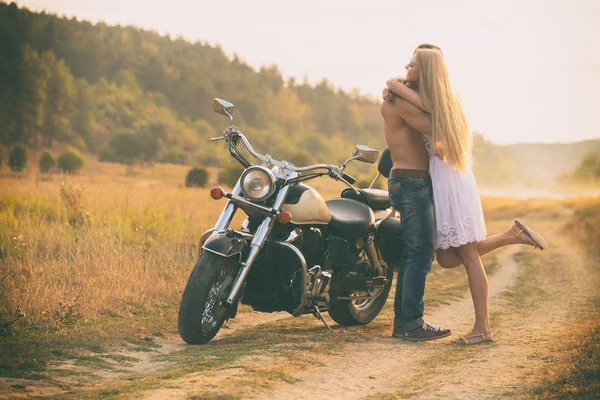 Amantes em uma motocicleta em um campo — Fotografia de Stock