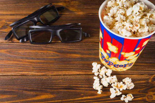Popcorn und Gläser auf Holzgrund. — Stockfoto