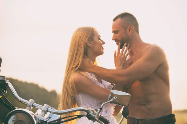 Milující pár na motorce v poli — Stock fotografie