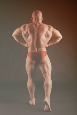 Karanlık bir arka plan üzerinde vücut geliştirmeci.