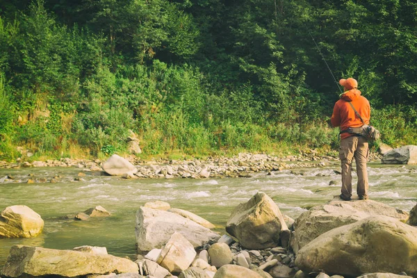 Pesca no rio.Um pescador com uma vara de pesca na proibição do rio — Fotografia de Stock