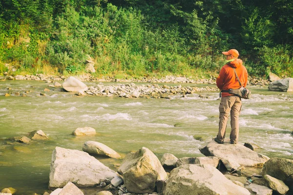 Pesca in river.Un pescatore con una canna da pesca sul divieto del fiume — Foto Stock