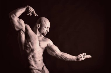 Bodybuilder posing in different poses demonstrating their muscles. Failure on a dark background. Male showing muscles straining. Beautiful muscular body athlete. clipart