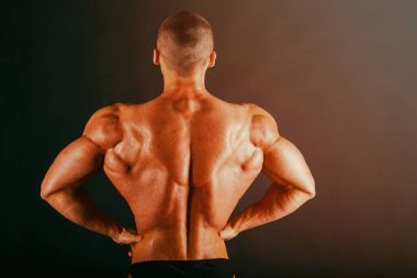 Karanlık bir arka plan üzerinde vücut geliştirmeci.