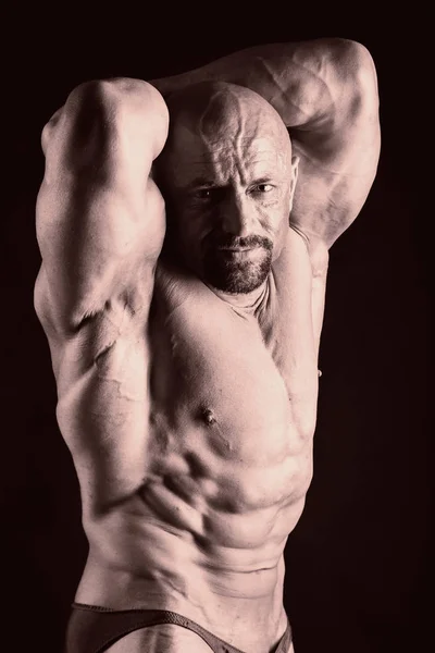 Bodybuilder posieren in verschiedenen Posen und demonstrieren ihre Muskeln. Scheitern auf dunklem Hintergrund. Männchen mit angespannten Muskeln. schöner muskulöser Körper Athlet. — Stockfoto