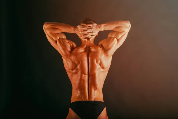 Bodybuilder auf dunklem Hintergrund. — Stockfoto