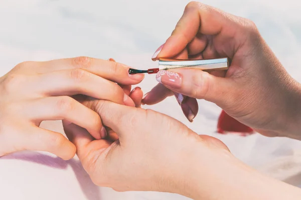 Um especialista faz uma manicure para uma menina em um salão de spa . — Fotografia de Stock