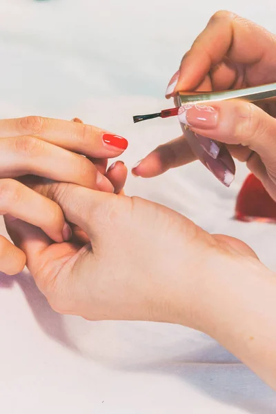 Een specialist heeft een manicure aan een meisje in een spa salon. — Stockfoto