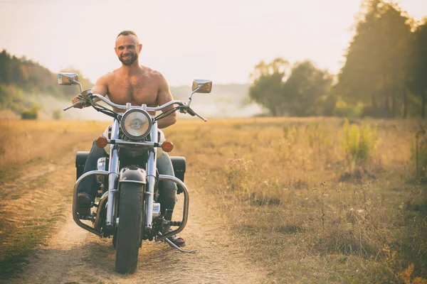 Macho auf einem Motorrad in einem Feld — Stockfoto