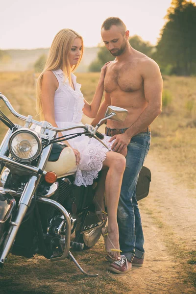 Любящая пара на мотоцикле в поле — стоковое фото
