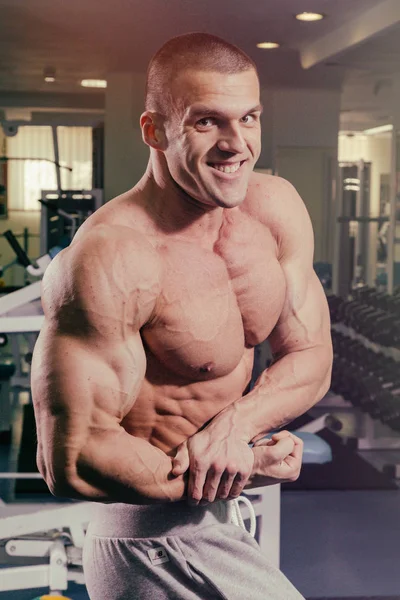 En man med en skivstång tränar biceps — Stockfoto