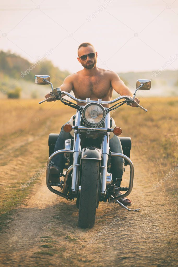 Macho on a motorcycle in a field