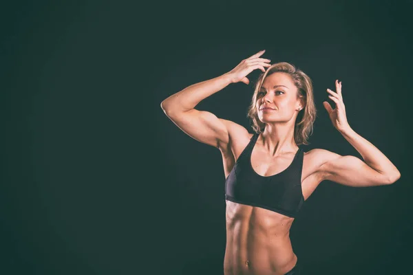 Fitness-Mädchen auf dunklem Hintergrund. — Stockfoto