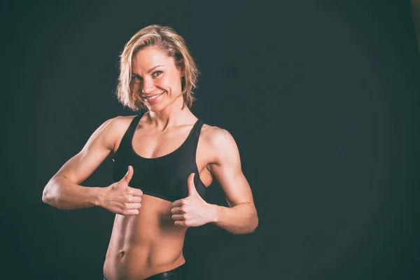 Menina fitness em um fundo escuro . — Fotografia de Stock