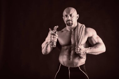 Bir adam siyah bir zemin üzerine muhteşem bir kas vücut ile