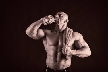 Bir adam siyah bir zemin üzerine muhteşem bir kas vücut ile