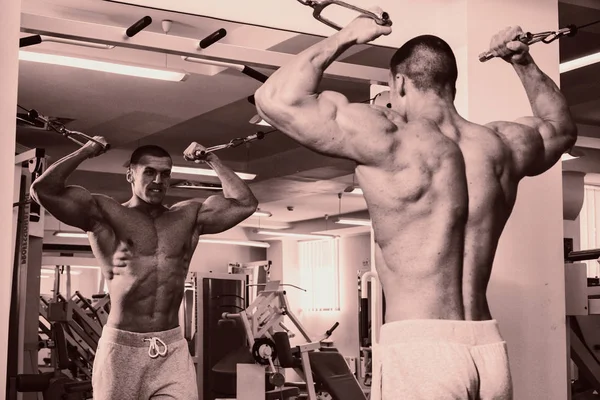 Un hombre muy fuerte se dedica al gimnasio —  Fotos de Stock