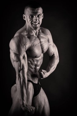 Karanlık bir arka plan üzerinde vücut geliştirmeci.