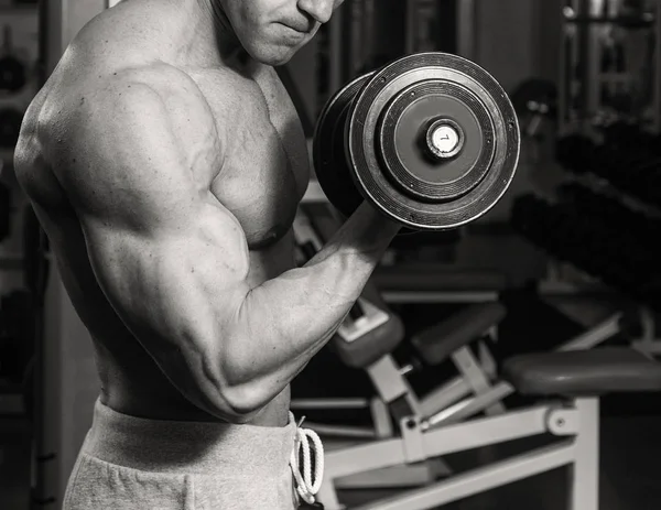 A very strong man is engaged in the gym — Stock Photo, Image