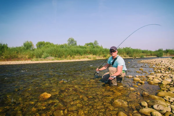 Fiskare fångar öring. Fiske för spinning. — Stockfoto