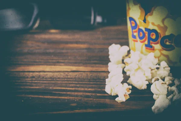 Popcorn a brýle na dřevěné pozadí. — Stock fotografie