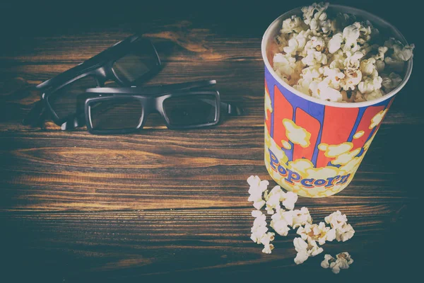 Popcorn i okulary na podłoże drewniane. — Zdjęcie stockowe