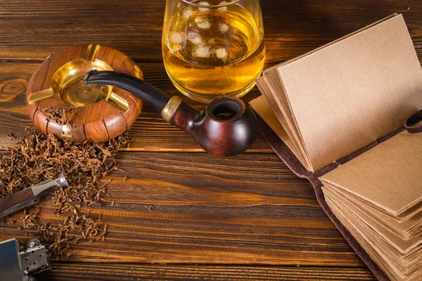 Smoking pipe, whiskey on a wooden background. — Stock Photo, Image