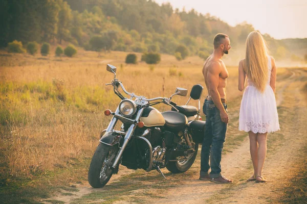 Amantes en una motocicleta en un campo —  Fotos de Stock